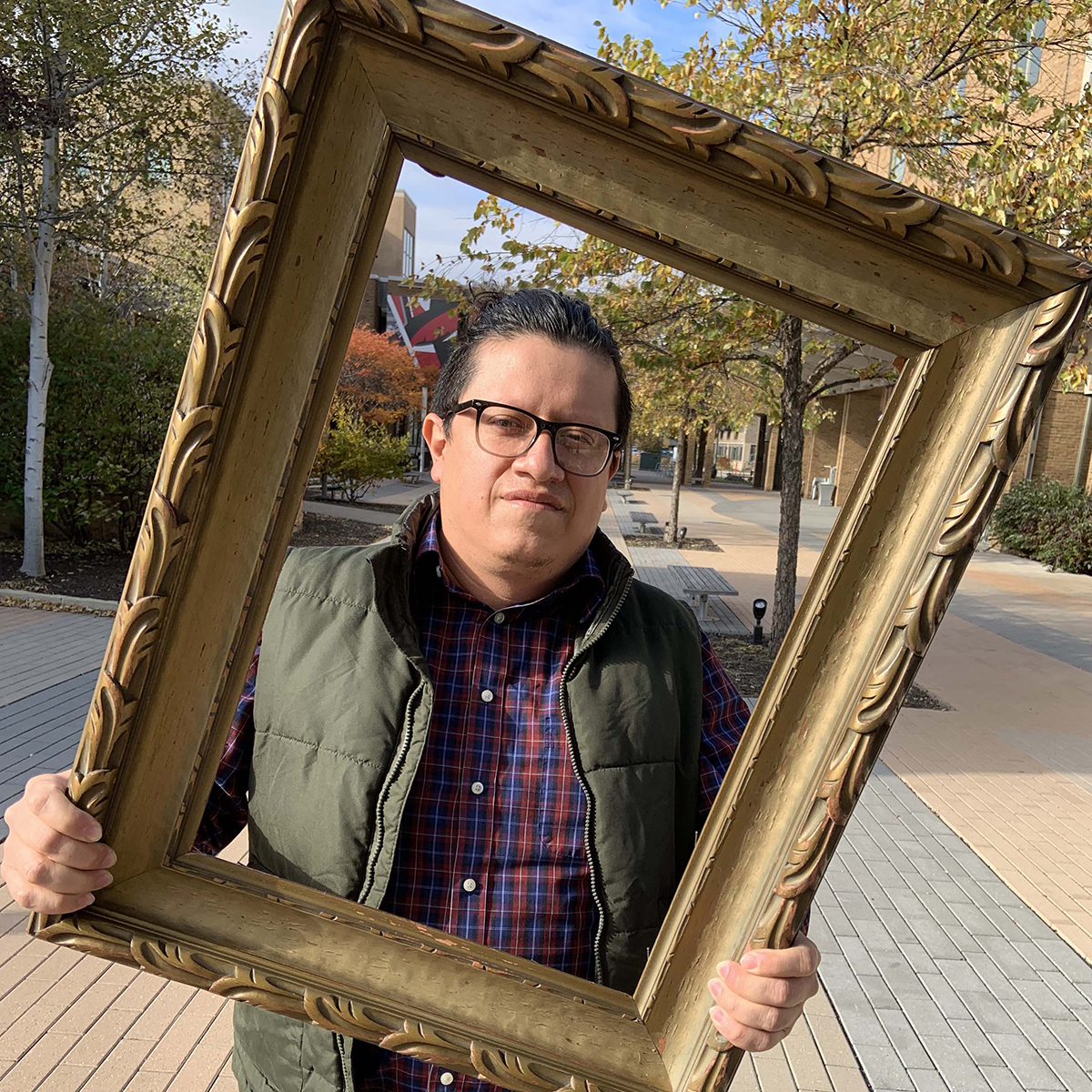 Man outside holding empty frame