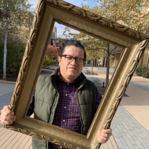 Man outside holding empty frame
