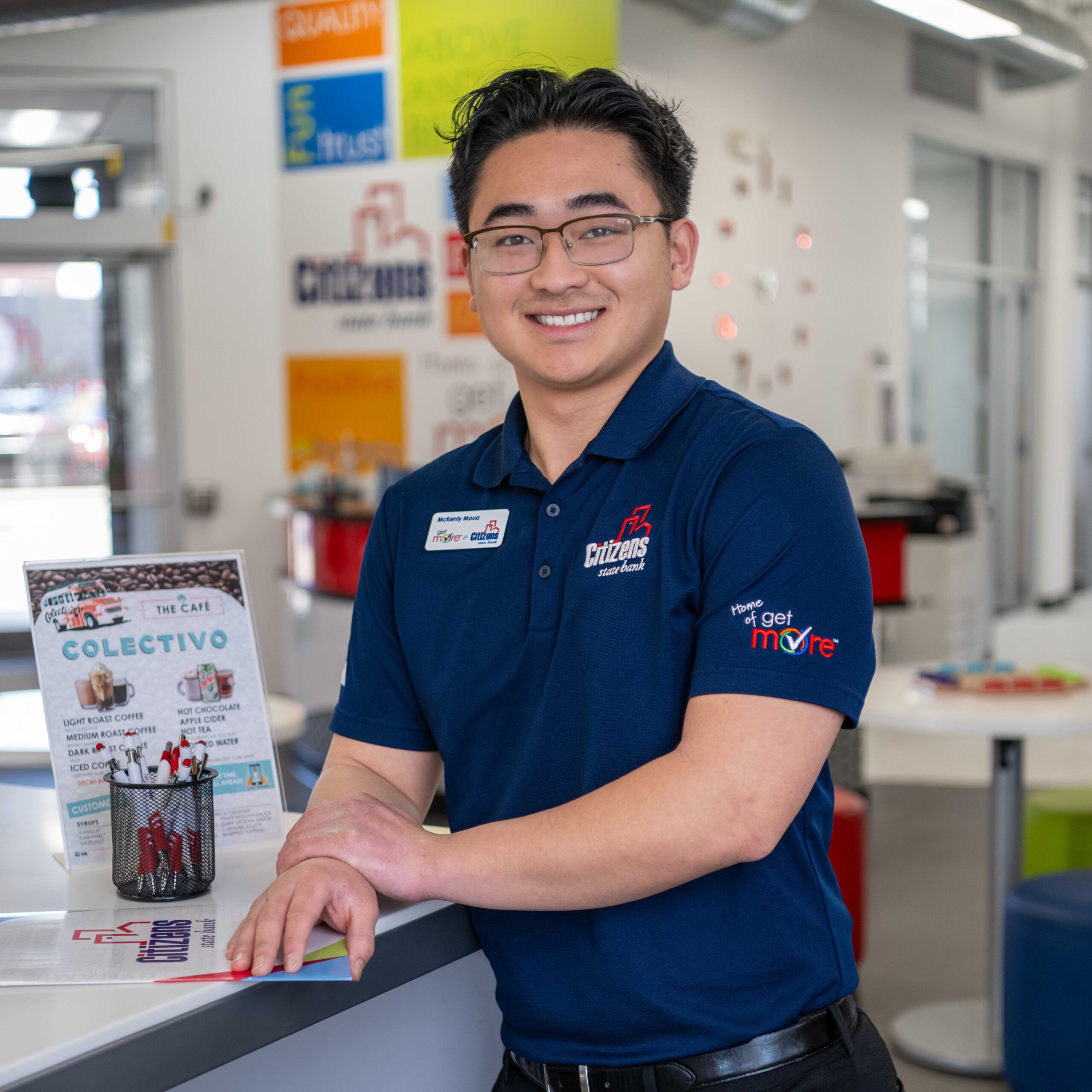 young man at desk smiling into camera
